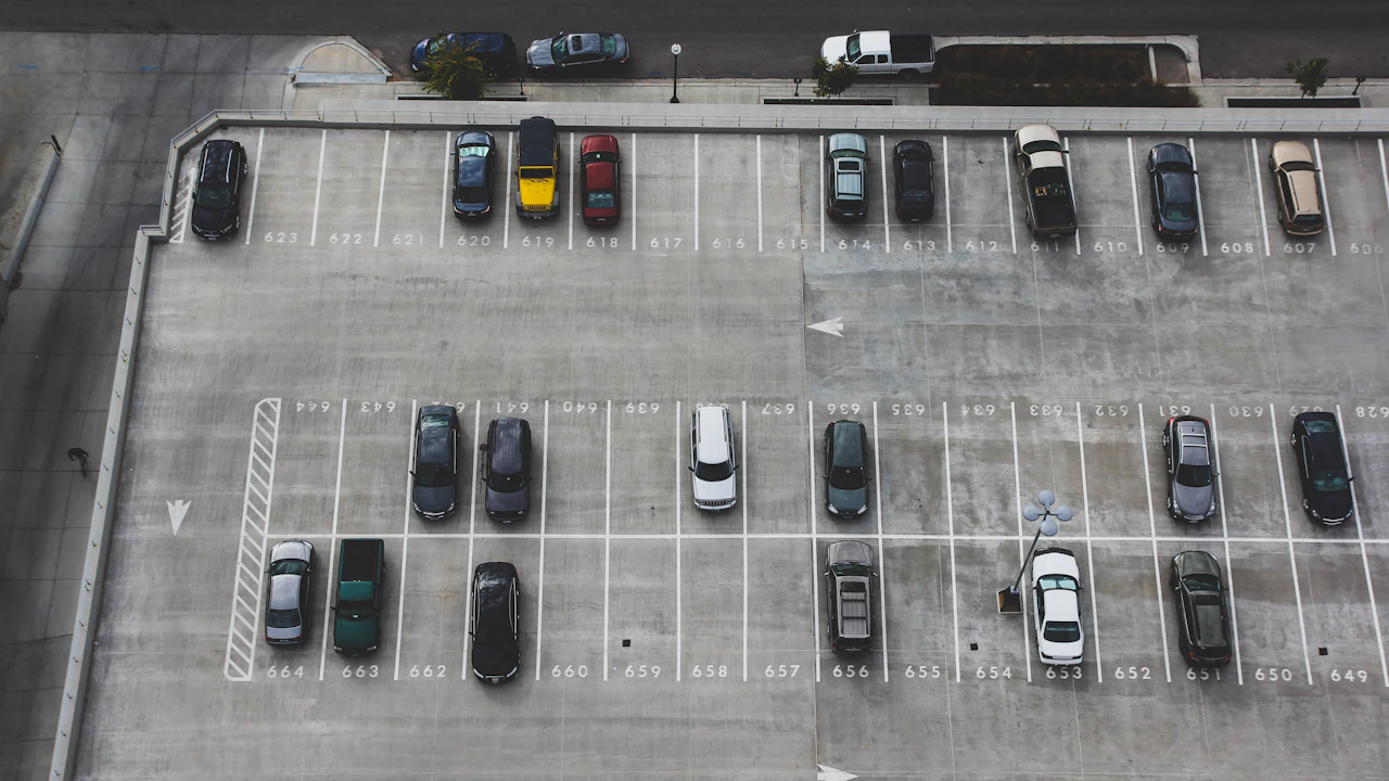 An aerial view of cars parked in numbered bays across a large asphalt lot