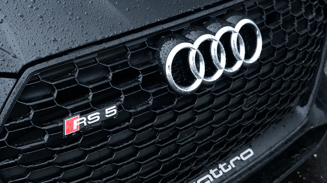 The four chrome rings on a rain-beaded black grille, an RS 5 badge below them
