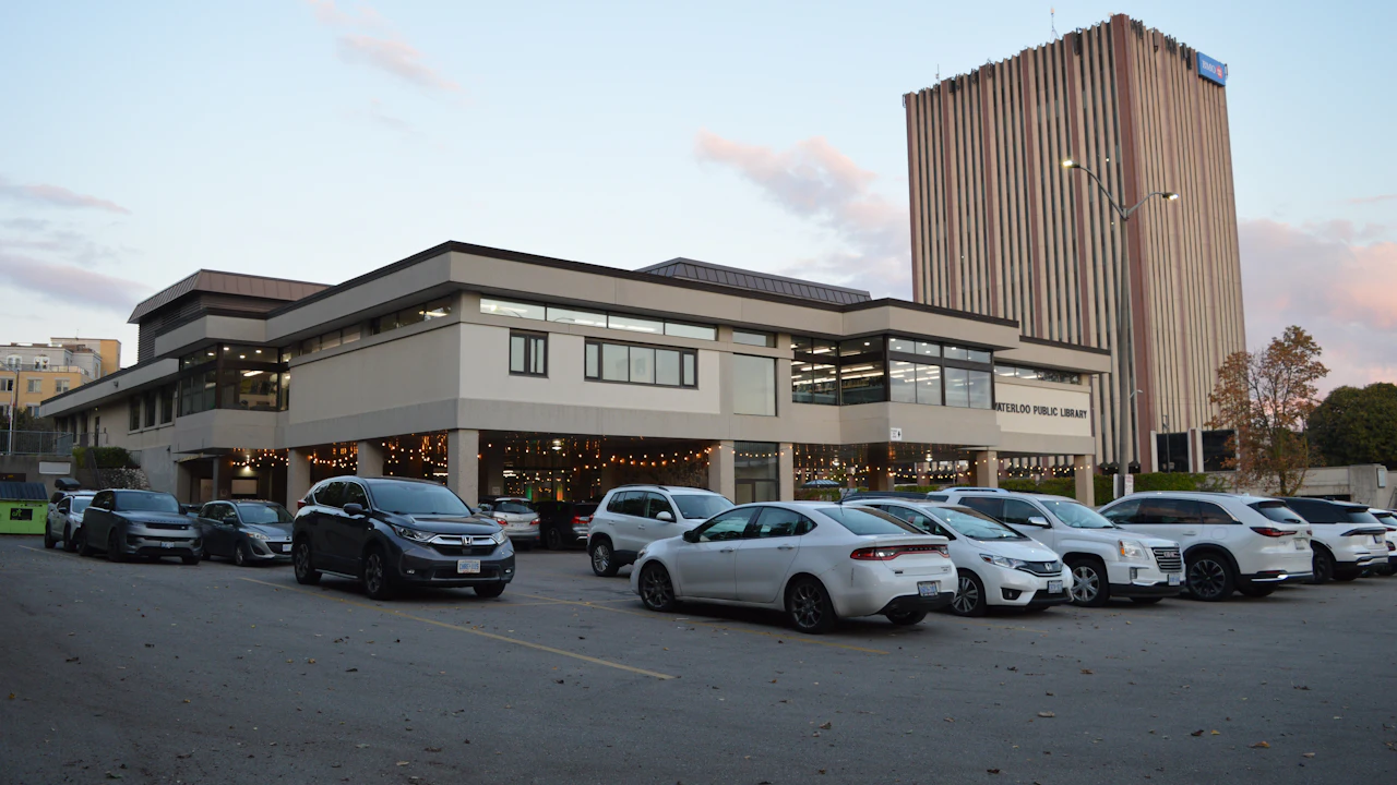 The exterior of a used-car dealership lot with rows of cars and a signed building