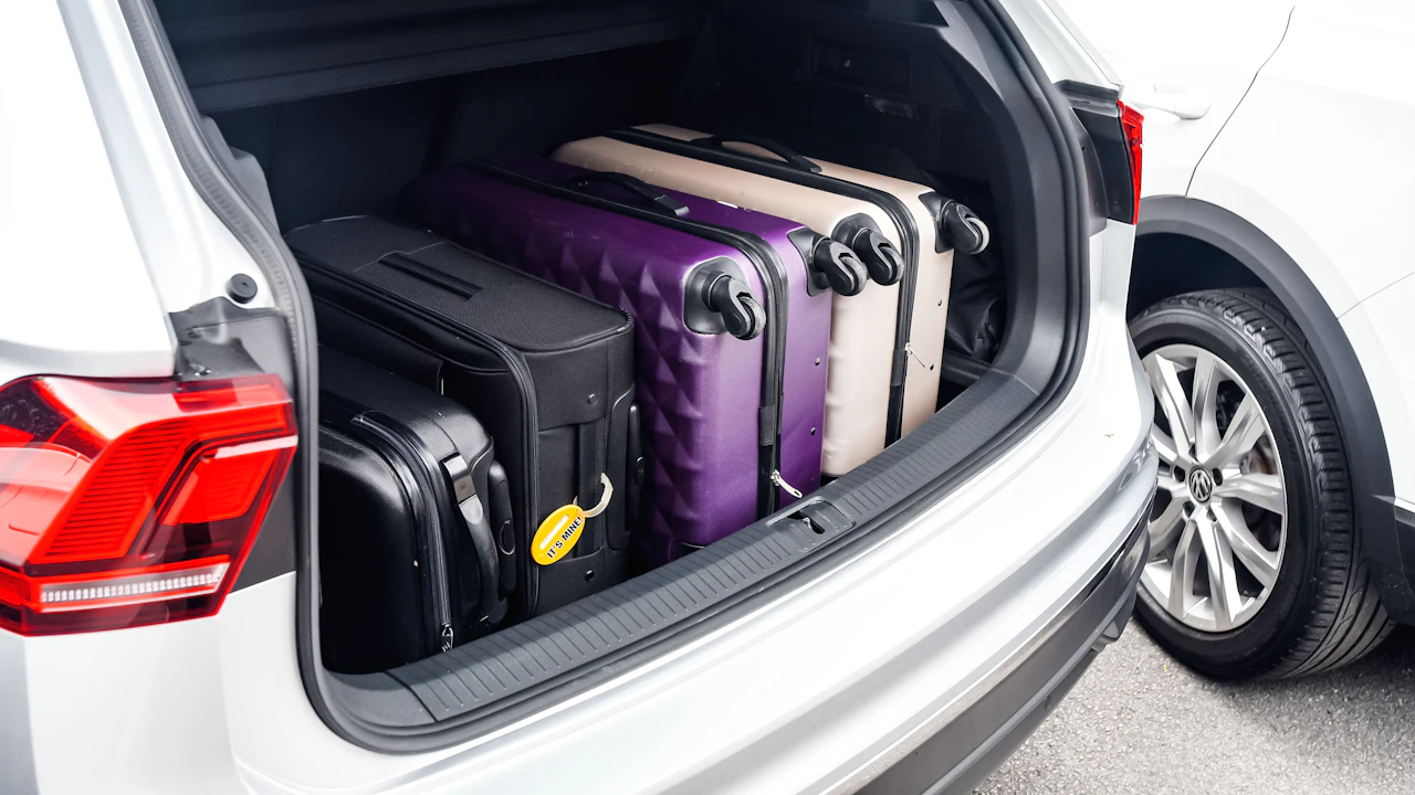 Suitcases packed upright in the open boot of an estate car