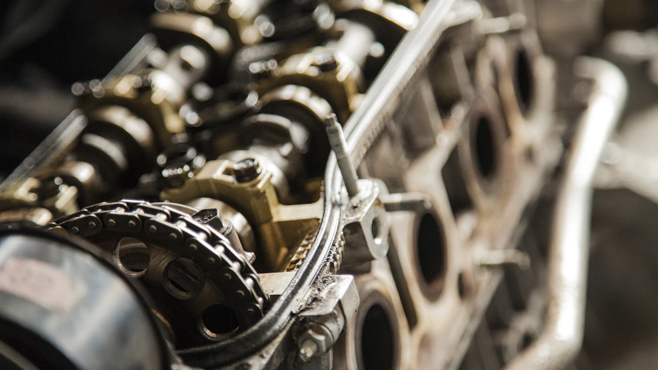 A cylinder head with its cover removed, camshafts and timing sprocket visible