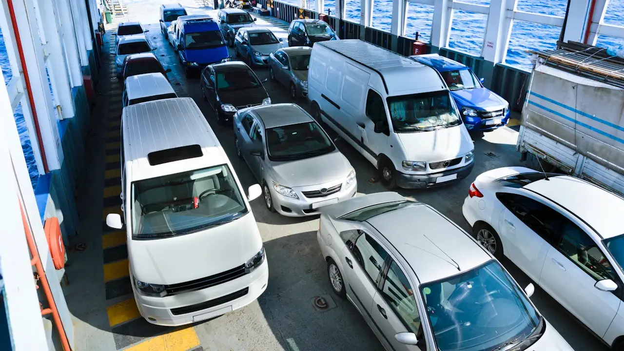 Cars and vans parked tightly on a vehicle deck, seen from above.