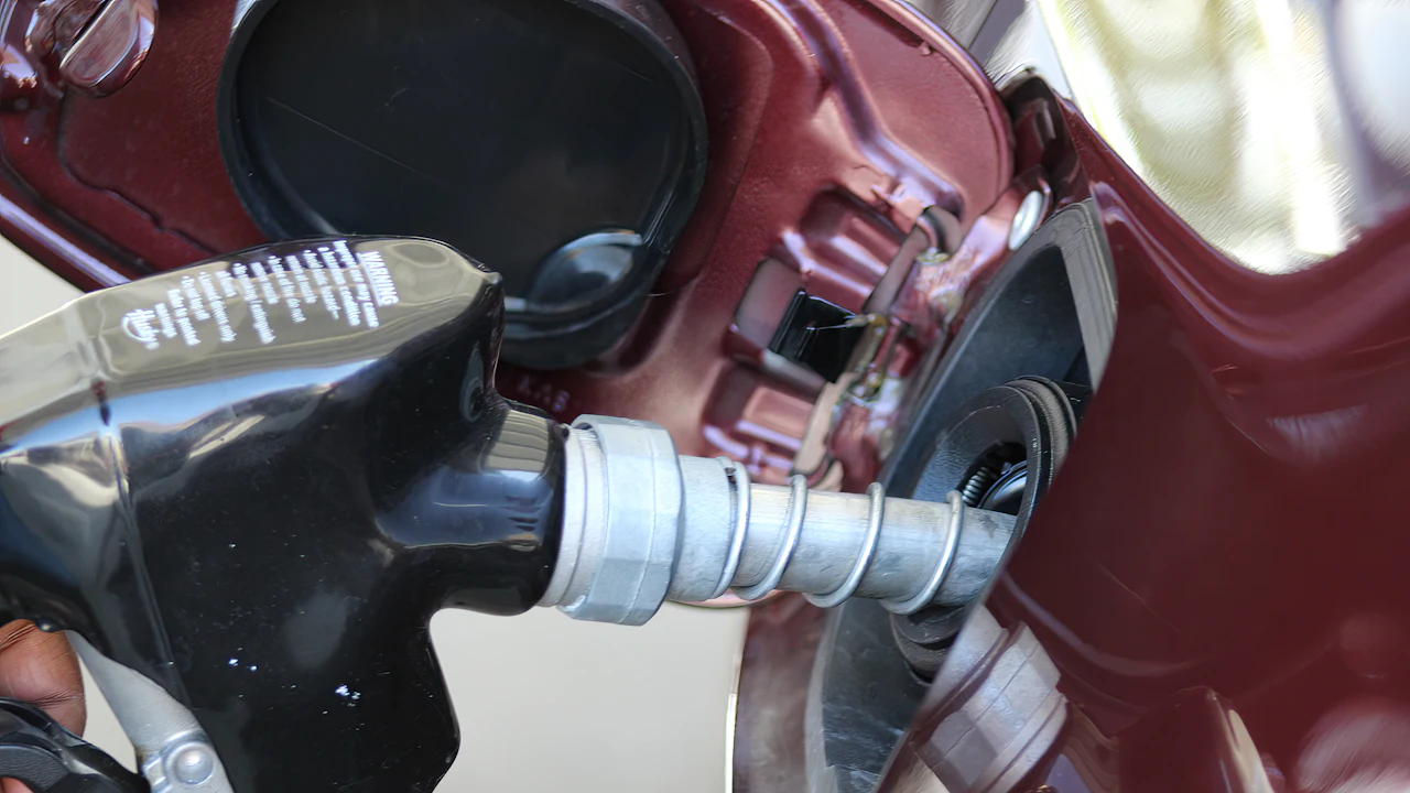 A fuel nozzle inserted into the filler neck of a vehicle, photographed close up