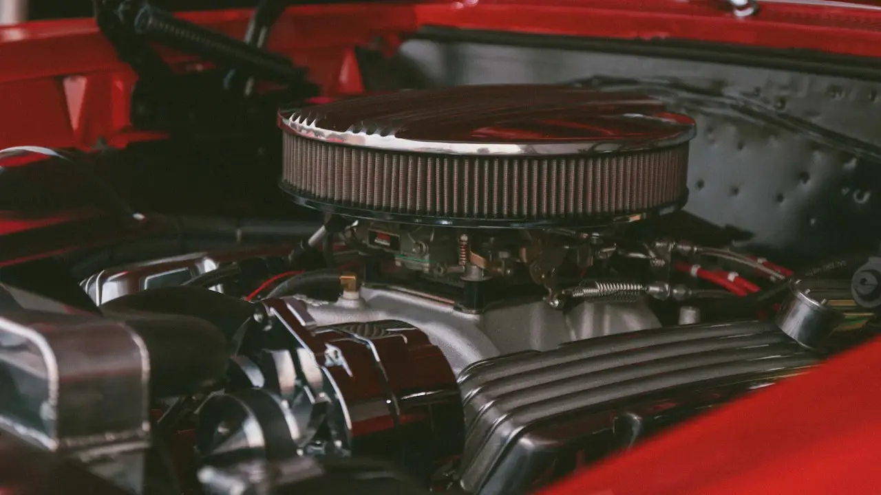 A V8 engine bay with a chrome air cleaner and finned valve covers.