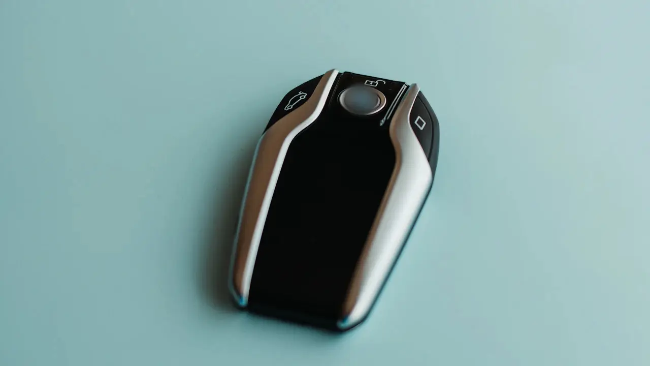 A smart key fob on a pale blue surface.