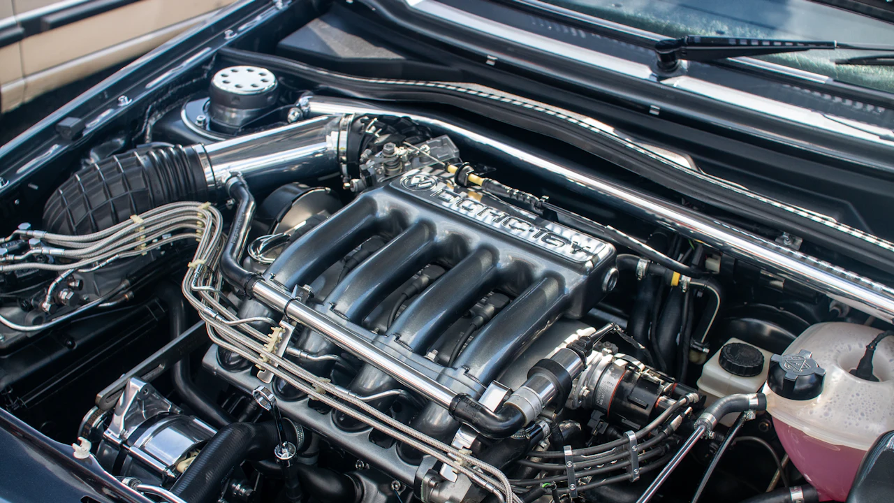 An engine bay viewed from above with the intake manifold and ignition components in view