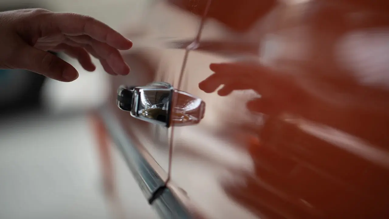 A car key fob passing between two people's hands.