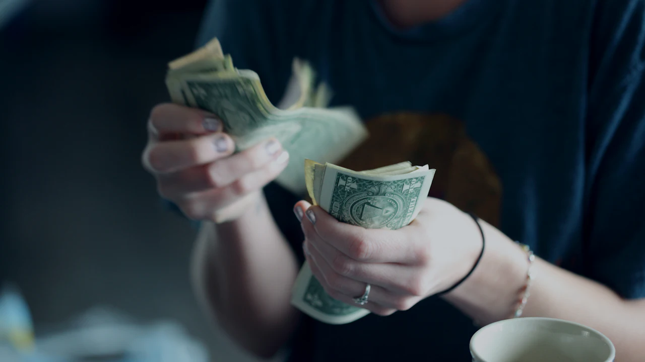A person counting banknotes in both hands