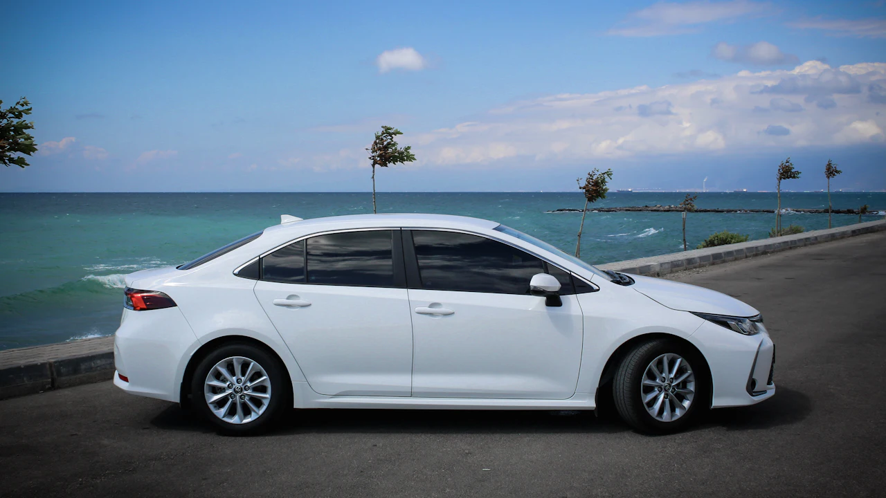white sedan on gray asphalt road during daytime