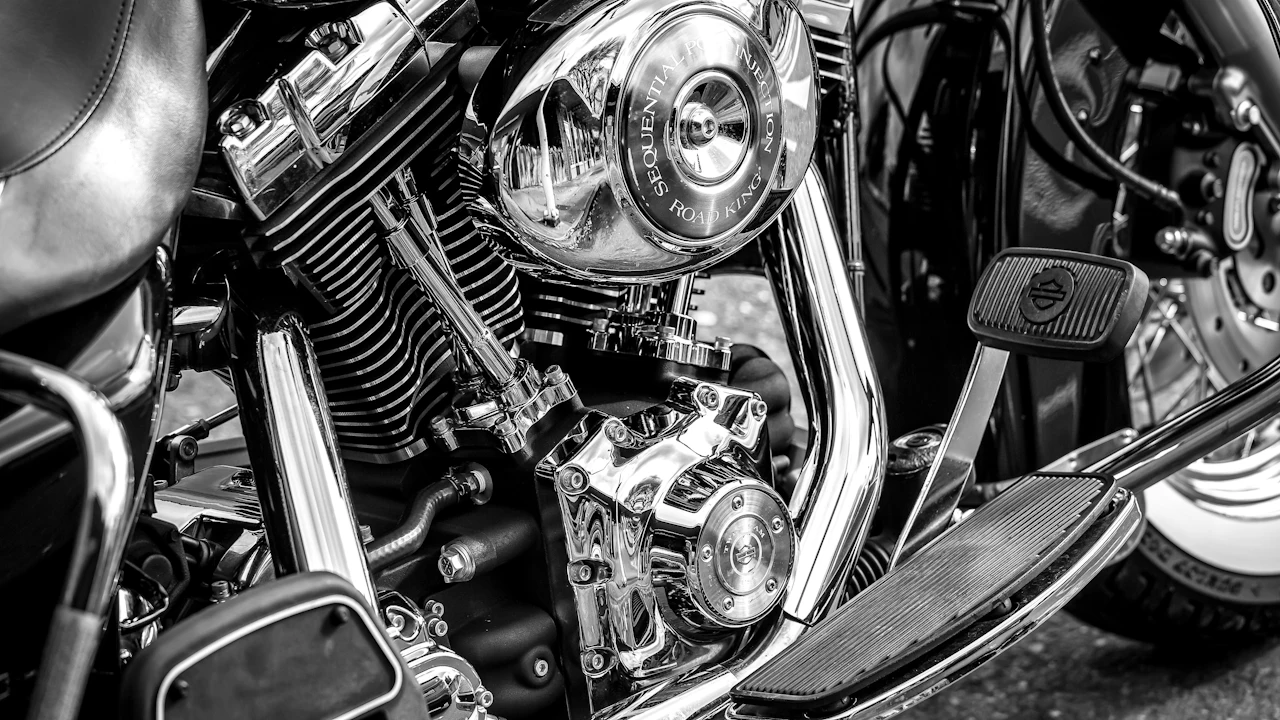 A chrome and black V-twin motorcycle engine photographed close up in monochrome, cooling fins, pushrod tubes and a polished air cleaner filling the frame