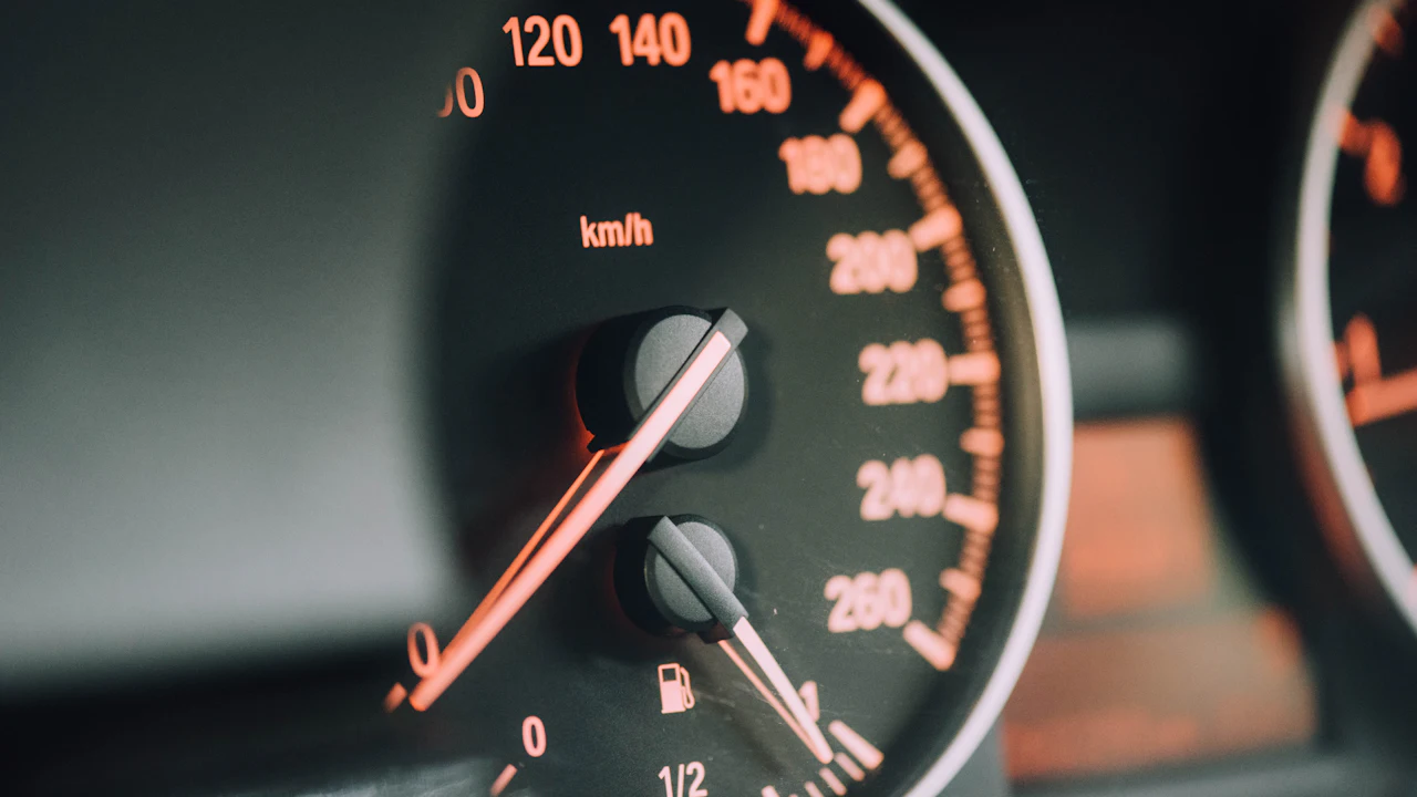 Close-up of a black analogue speedometer in a car instrument cluster