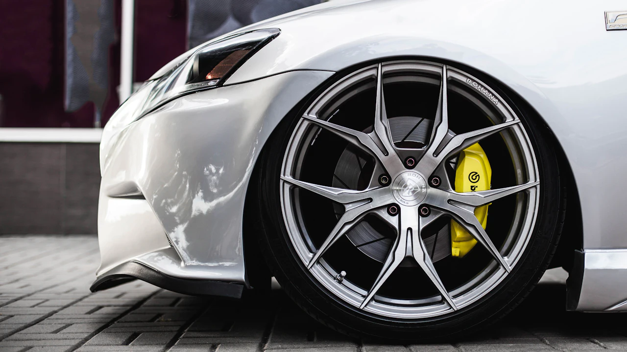 A low-profile tyre on a large alloy wheel photographed at the front corner of a white car