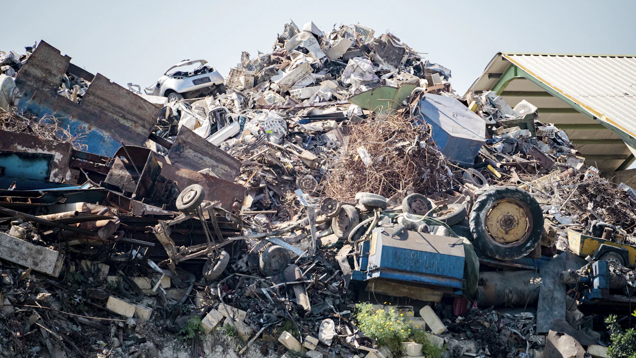 A heaped pile of crushed vehicles and scrap metal in a breaker's yard