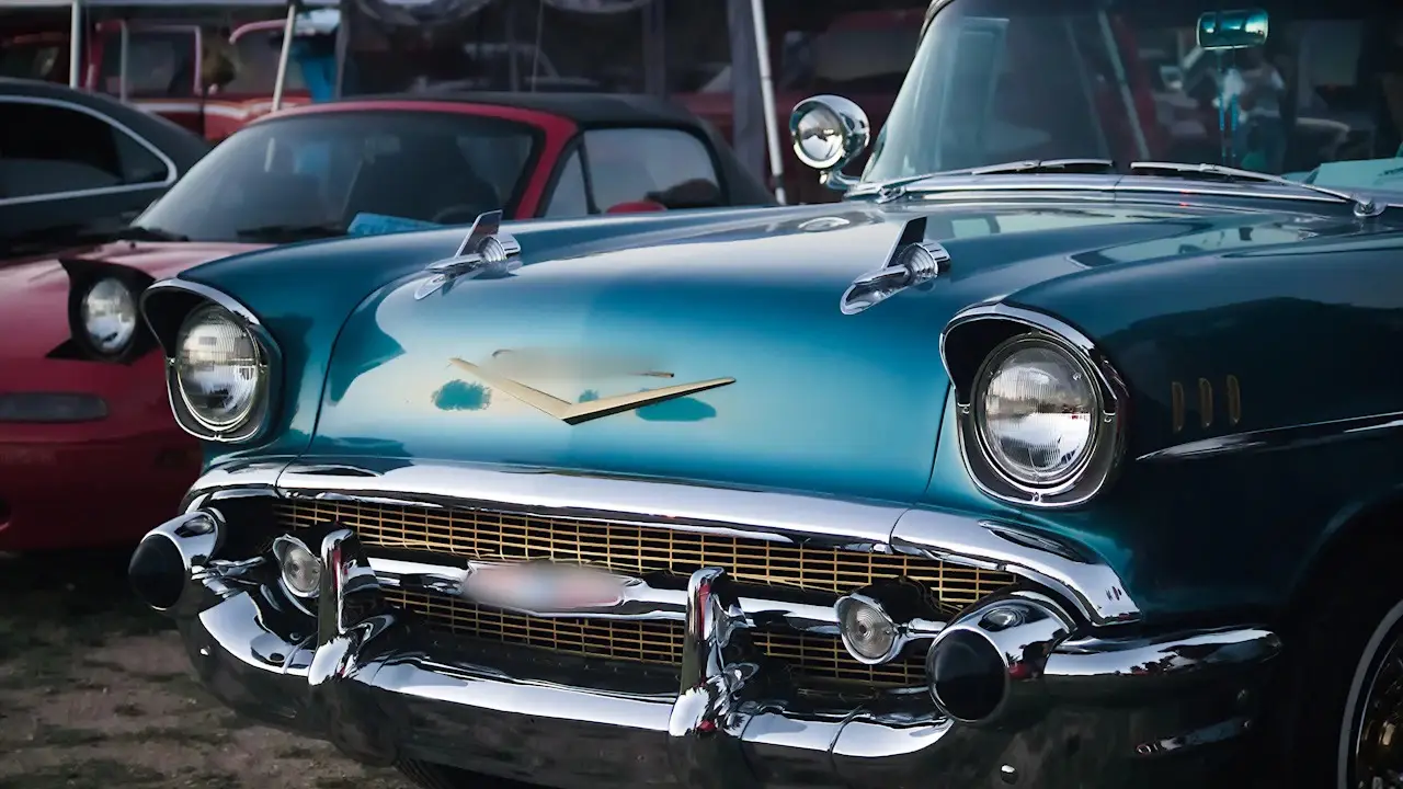 The chrome front of a two-tone classic sedan at a car show.