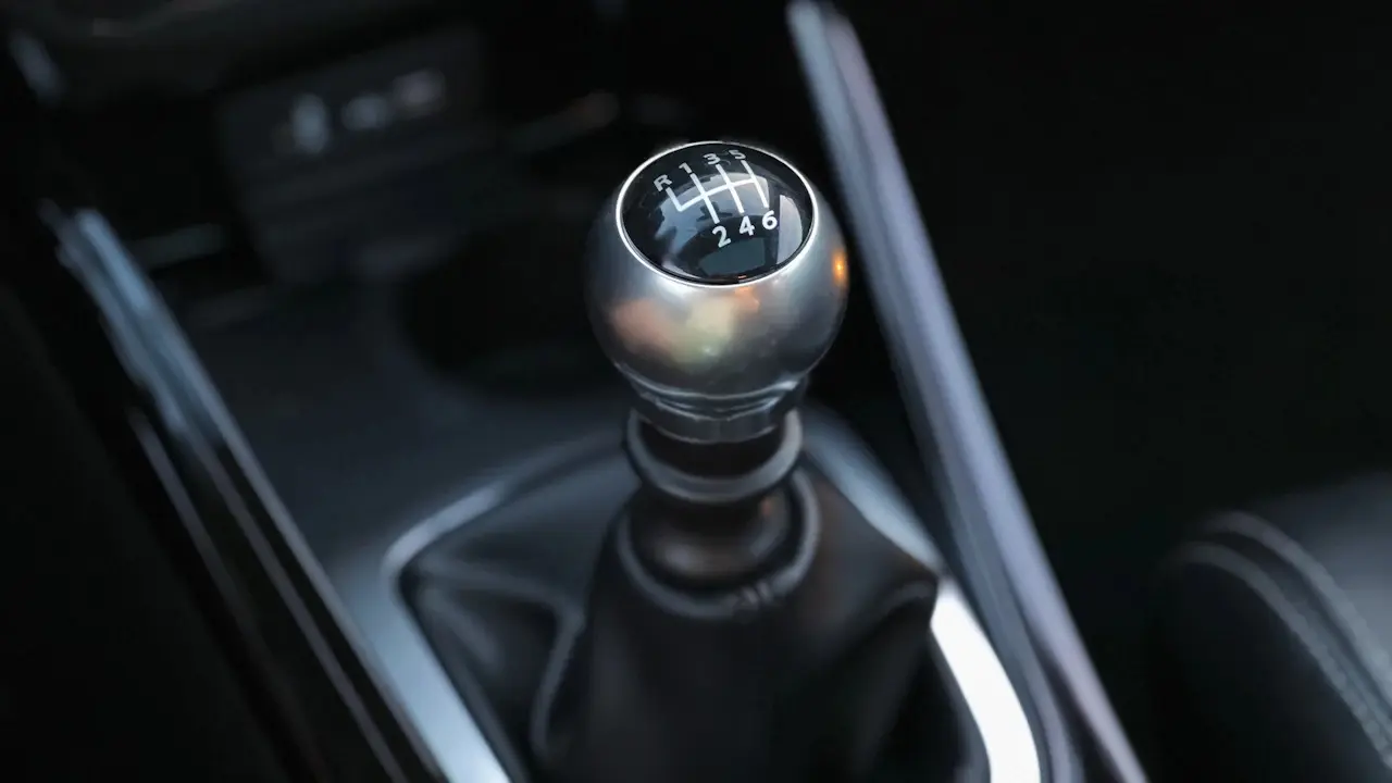 A manual gear lever in a car's centre console.