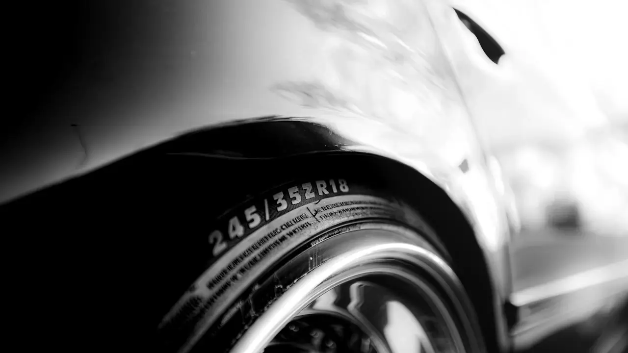 Close-up of a car tire’s sidewall with its size and load markings.