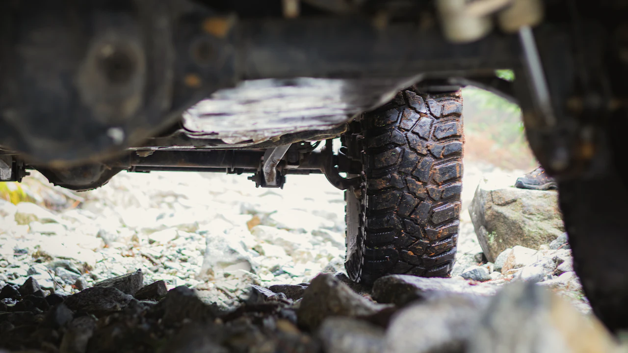 The underside of a vehicle's front suspension and lower control arm, seen from beneath