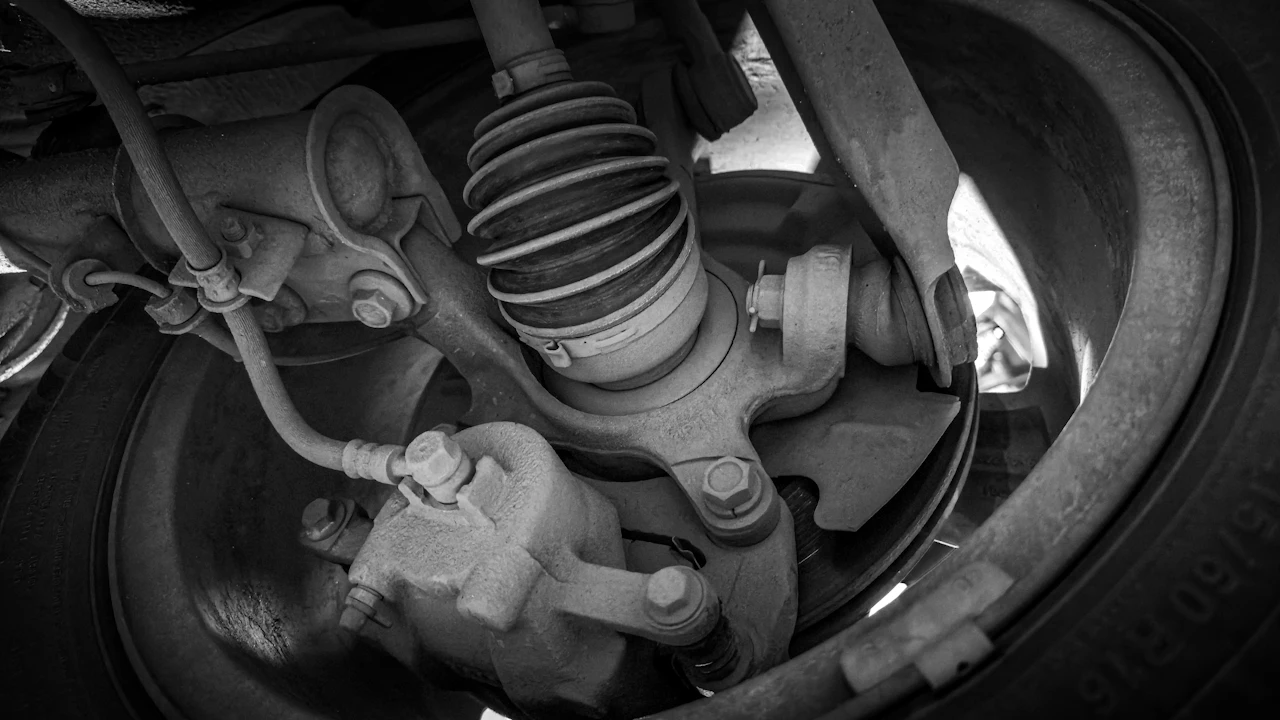 A car's CV joint and its ribbed rubber boot, seen from underneath the vehicle