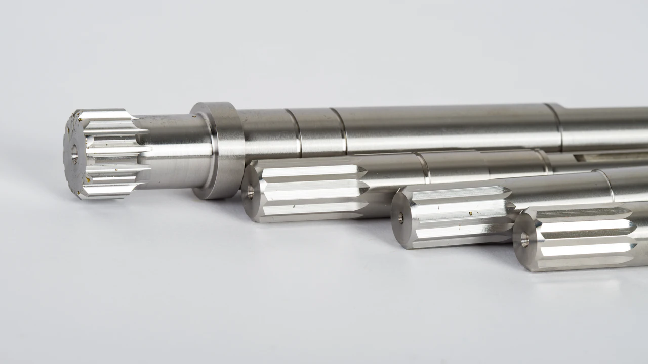 Splined metal drive shafts on a plain background