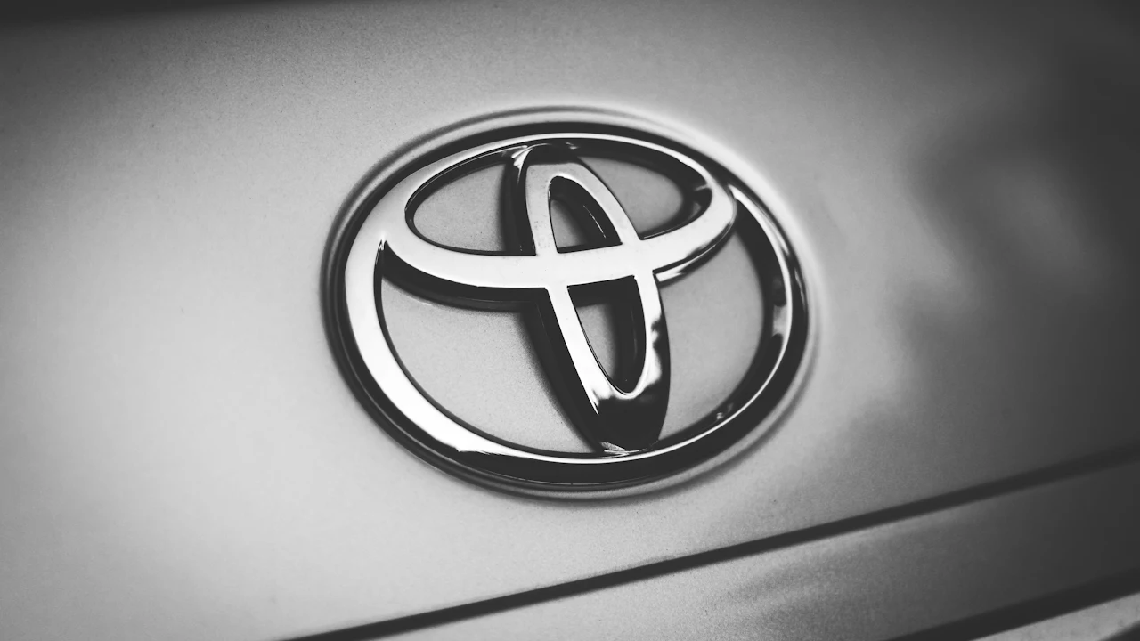 The front of a silver saloon photographed close, its grille and maker&rsquo;s badge filling the centre of the frame