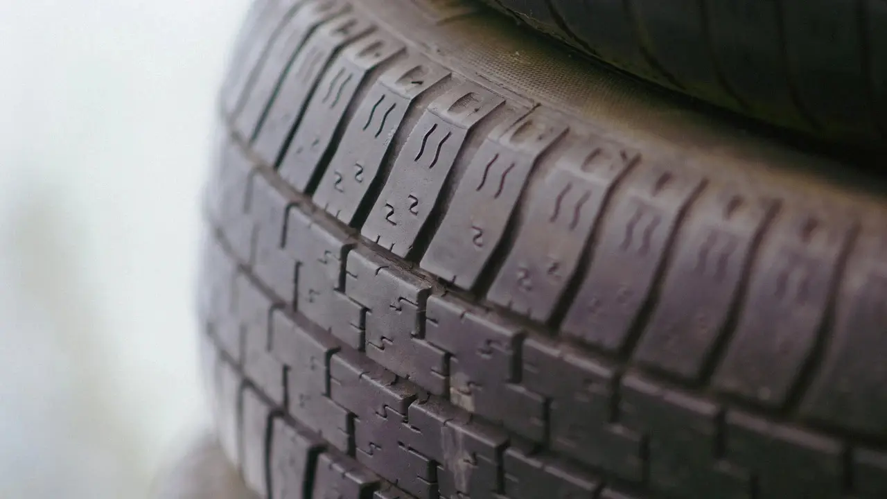 Close view of a car tyre's tread blocks and sipes.