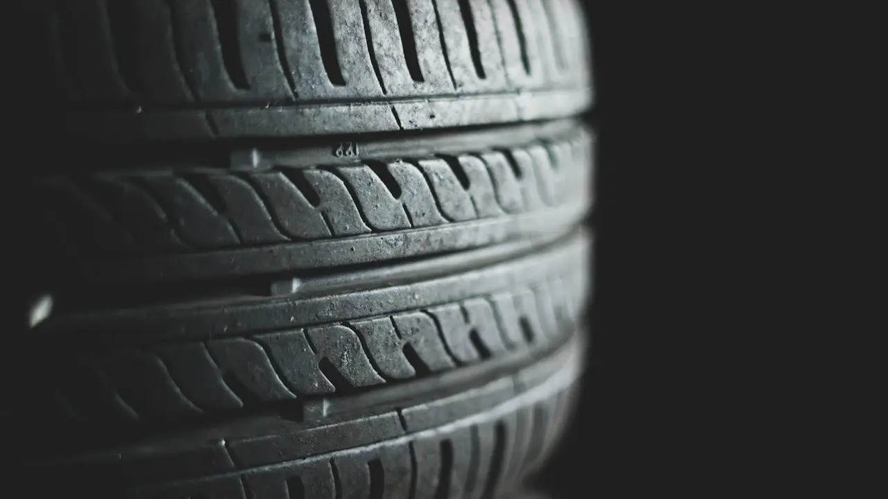 Close view of a tire's tread blocks and grooves in low light.