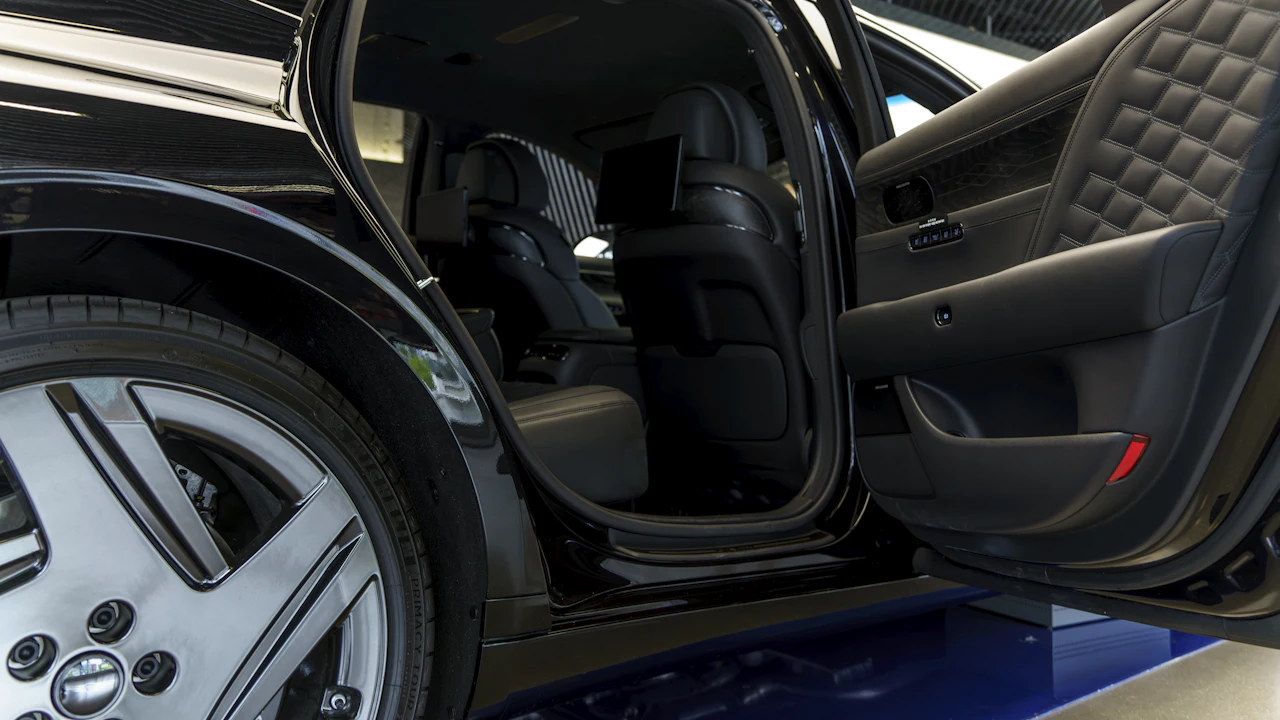 An open car door showing the door sill and the pillar where the certification label is fixed