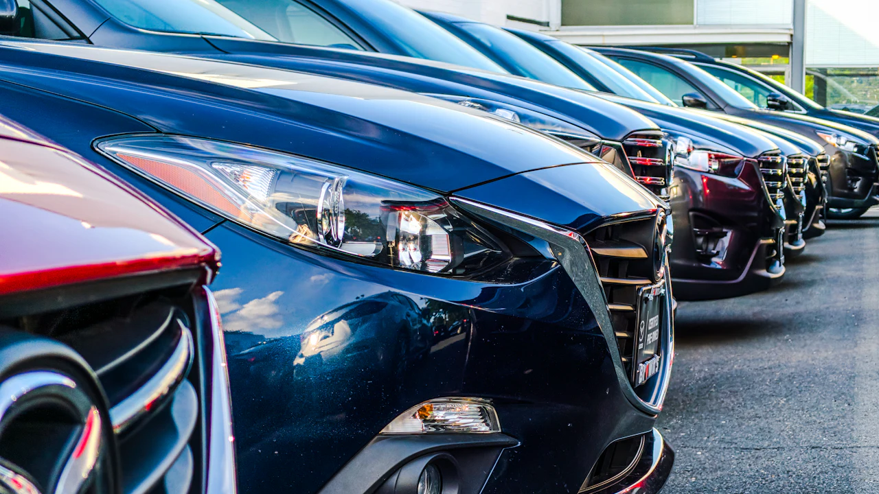 Used cars parked in a row on a dealership forecourt