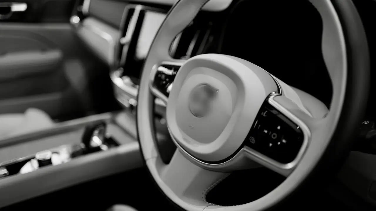 A Volvo steering wheel and centre console, photographed in black and white.