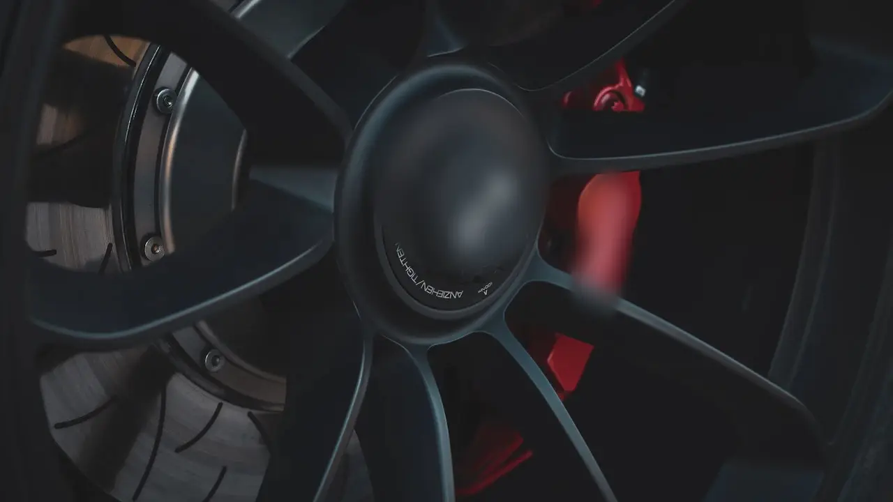 A wheel with a red brake caliper and the brake rotor behind its spokes.