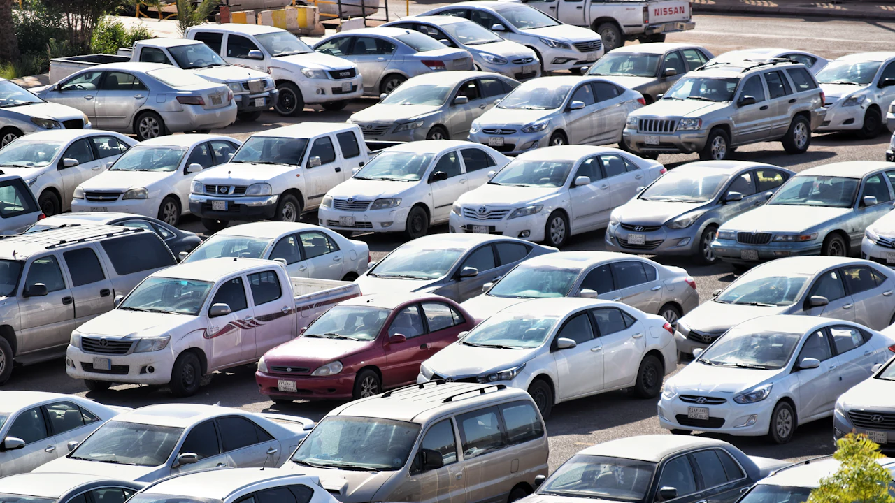 A crowded used car lot filled with cars of mixed ages and colours