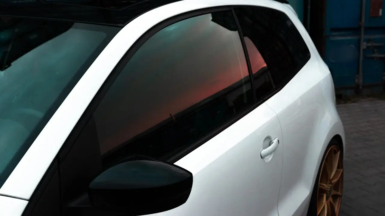 A white hatchback with dark-tinted side windows.